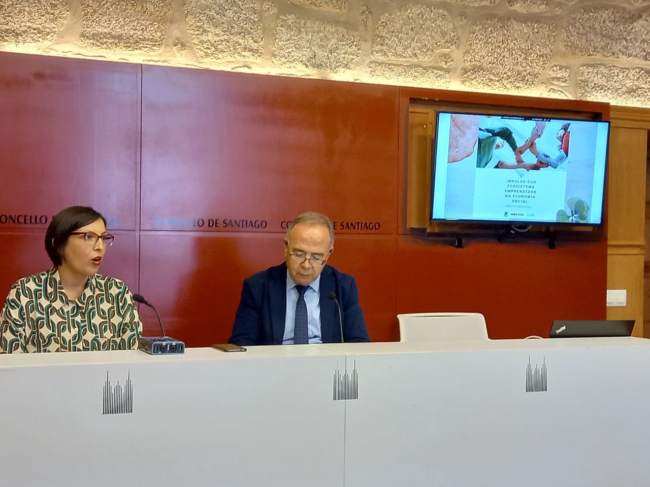 El alcalde de Santiago, Xosé Sánchez Bugallo y Ana Olveira, presidenta de la Unión de Cooperativas EspazoCoop, presetaron en rueda de prensa el programa